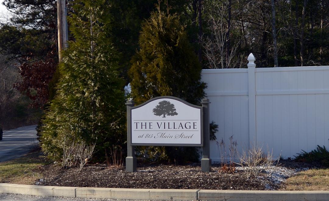 a sign in front of a white fence